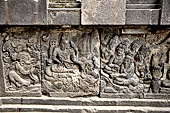 Prambanan - Ramayana reliefs. Opening scene from Ramayna relief series: Vishnu, in the central panel, with adoring Garuda to his right, and five supplicants to his left, on inner side of balustrade of Shiva temple.  